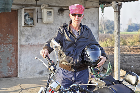 印度内地棚屋外的高加索骑自行车者图片