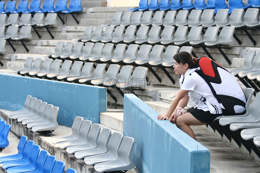 一名亚洲运动女运动员坐在体育场上图片