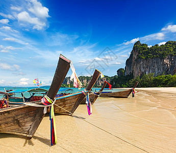 泰国海滩上长尾小船旅游一条线蓝色旅行热带岩石石头团体图片