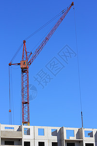 建筑工地上的红色起重机和蓝蓝天空摩天大楼生长建筑学项目机械商业住房黄色技术金属图片