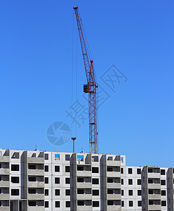 建筑工地上的红色起重机和蓝蓝天空金属工程建筑学项目商业住房摩天大楼技术机械蓝色图片