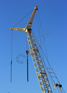 建筑工地上的黄黄色起重机和蓝色天空黄色商业建筑学住房机械项目金属生长工程起重机图片