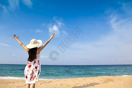 在海滩上快乐的女人假期帽子闲暇乐趣海浪晴天季节热带自由女孩图片