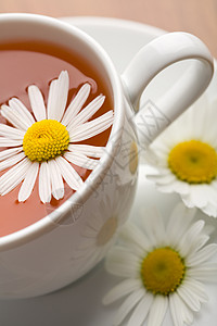 白杯草药茶和甘菊花杯子叶子餐厅芳香补品草本植物咖啡店花瓣早餐桌子图片