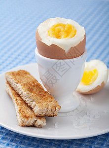 蛋杯中的煮鸡蛋黄色美食棕色产品杂货食物白色面包早餐盘子图片