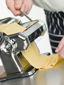 新鲜鸡蛋意面片在意大利面机中滚动美食厨房面条机器具外表食物蛋黄摄影系列中年图片