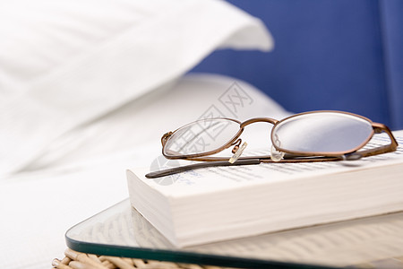 以眼镜和书本为焦点的空卧室小说家具床头柜设计水平平装生活枕头阅读房间背景图片
