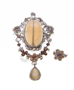 在背景上有着不同宝石的胸针首饰礼物玻璃火花珠宝蓝色项链金子奢华别针图片