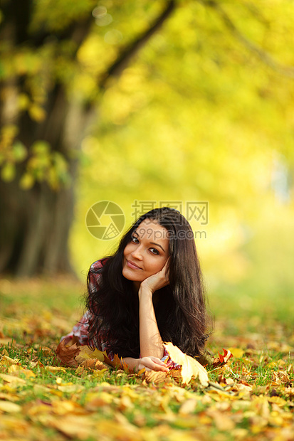 秋叶中的妇女脚尖微笑头发女性公园季节女士金发女郎团体毛衣橙子图片