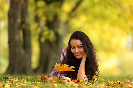秋叶中的妇女脚尖橙子公园毛衣乐趣金发女郎眼睛季节感恩女士头发图片