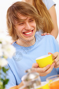 快乐的年轻人喝茶饮料蓝色闲暇厨房乐趣生活杯子微笑男人成人图片