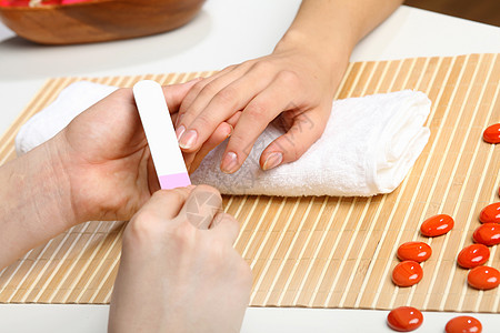 女人正在修指甲手指福利沙龙美甲身体护理美容师治疗女士毛巾图片