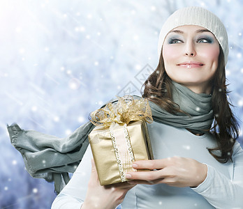 圣诞礼物的美丽快乐女孩 雪花衣服展示礼物幸福头发乐趣惊喜手套蓝色女士图片