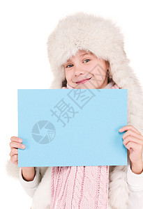 身戴冬帽 带空白板的女孩微笑蓝色帽子快乐孩子卡片木板棉被展示广告图片