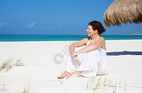 在海滩上快乐的女人海洋女性天空旅行晴天自由微笑天堂蓝色福利活力高清图片素材