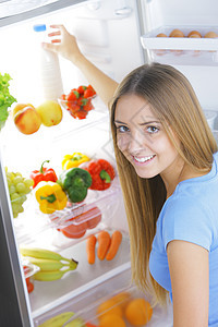 冰箱中的牛奶生活瓶子女士金发女郎蓝衬衫饮食蔬菜水果表达微笑图片