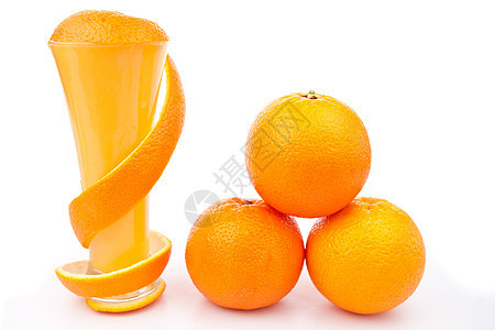 橙色皮环绕着杯子 靠近一堆橘子图片