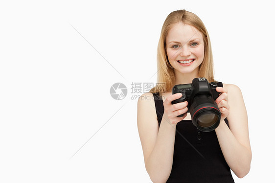 女人在微笑时拿着SLR摄像机图片