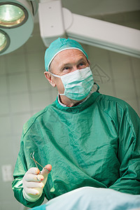 手持剪刀的微笑外科医生技术员制服医院男人专注身体保健手术专家卫生图片