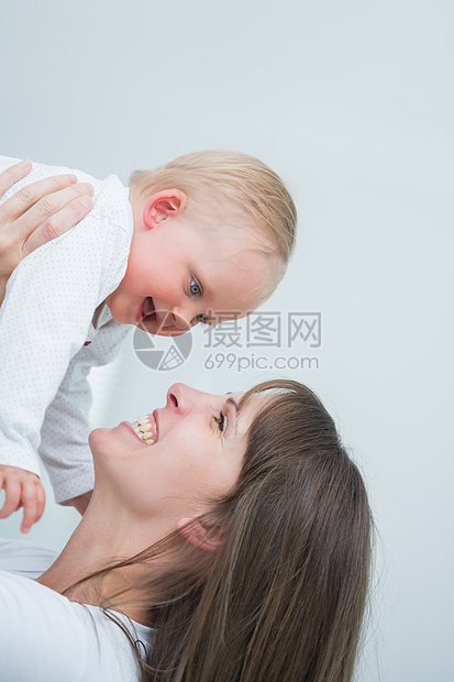 带着婴儿的微笑的母亲快乐双手团结女性感情女士金发女郎安全童年家庭图片