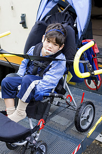 乘坐校车轮椅电梯的残疾小男孩婴儿车残障骑术机动性学校男生运输安全人士民众图片