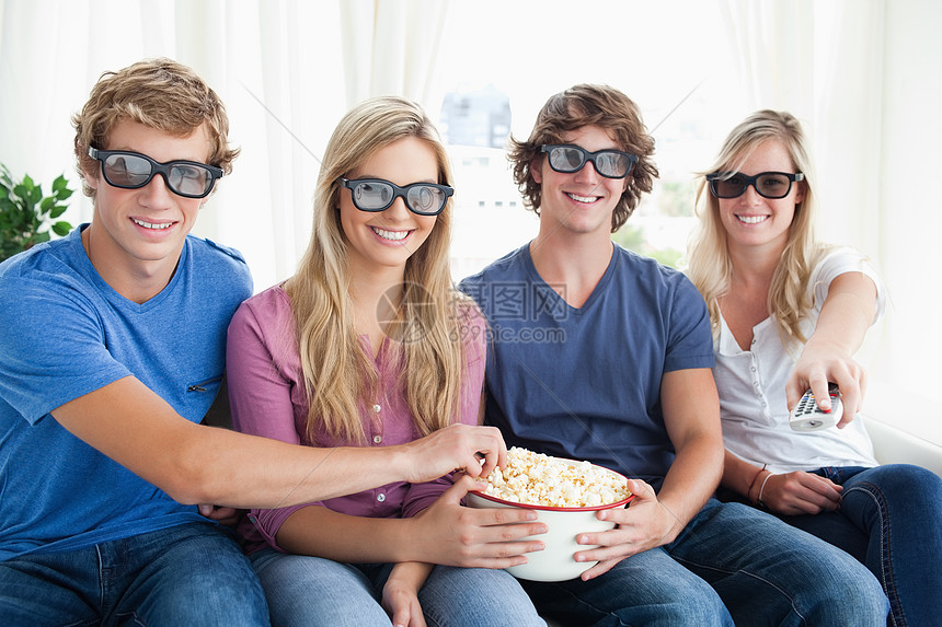 朋友们在吃爆米花和看3D电影时微笑图片