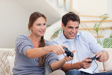 玩电子游戏的情侣技术快乐闲暇幸福友谊房子乐趣长椅控制竞赛图片
