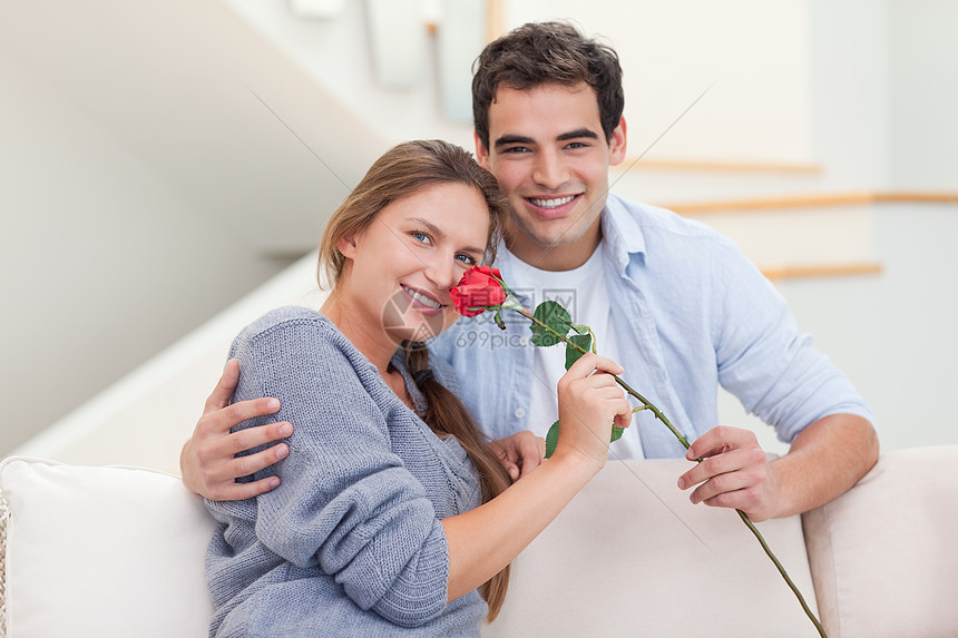 年轻男人向女友献玫瑰的青男子图片