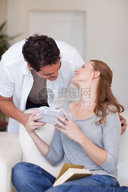 男人给他的女朋友送礼物情人生日丝带庆典夫妻亲热沙发恋人幸福微笑图片