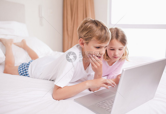 儿童使用笔记本电脑好奇心享受家庭互联网女孩们娱乐男孩们童年幸福闲暇图片