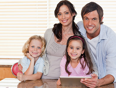 使用平板电脑一起微笑的家族图片