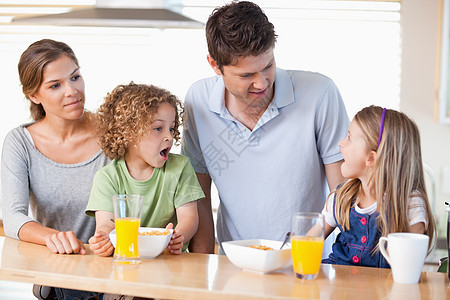 家庭吃早餐家长团结男人乐趣果汁混血四个人房子孩子幸福图片