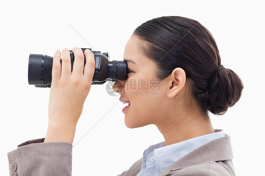 商业女商务人士透过望远镜观看的侧面视图图片