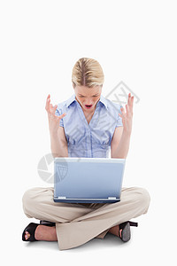 坐着的女人对她的笔记本电脑大喊大叫图片