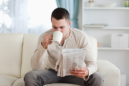 男人在喝茶时看新闻图片