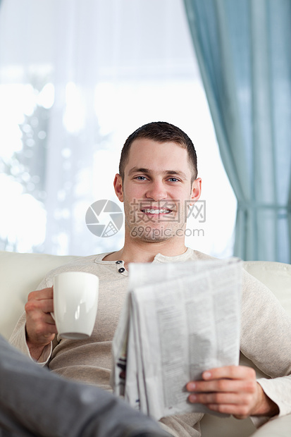 一个男人在看新闻时喝茶的肖像图片