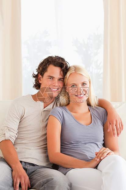 坐在沙发上的一对年轻夫妇的肖像图片