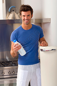 男人在厨房里喝着一瓶牛奶微笑便装成年人成人房子家用电器食物控股冰箱瓶子图片
