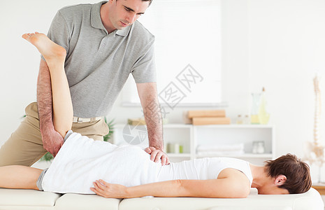 脊椎按摩师伸展顾客的腿图片