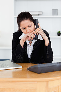 不满的女商务人士在办公室进行电话通话图片