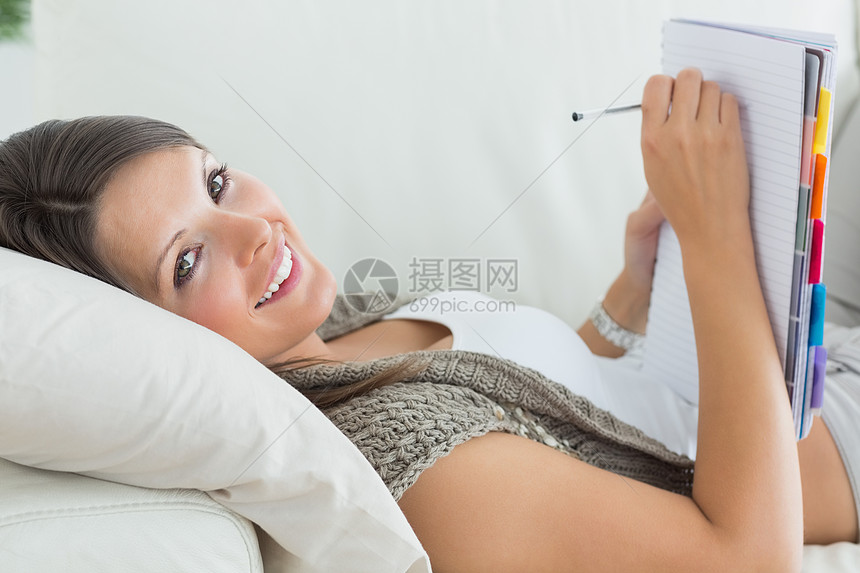 女人躺在沙发和写作上图片
