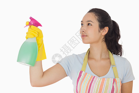年轻妇女喷洒清洁剂图片