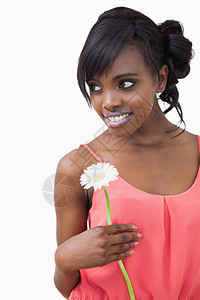 女孩拿着一朵花 微笑着与白色背面对立图片