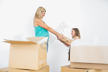 幸福的母亲和女儿拿着搬家箱图片