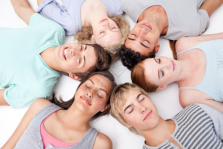 青少年与头头一起躺在地板上男人多样性男朋友桌子女性地面青年女孩团体乐趣图片