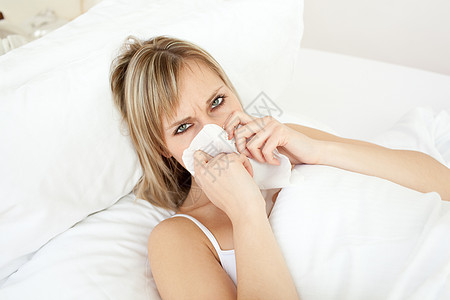 躺在床上的金发病女人速度伤害女士疾病发烧鼻塞毛衣手帕手指喷嚏背景图片