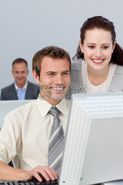微笑的商业伙伴在计算机中共同工作和男性帮助管理人员男人团队办公室桌子环境电脑成功图片