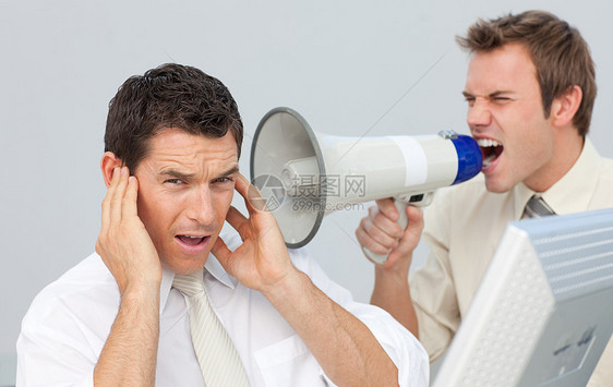 商务人士用扩音器对同事大喊大叫扬声器办公室老板广告说话放大器惩戒播送领导公告图片