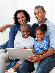 使用笔记本电脑对非裔美国人家庭微笑图片