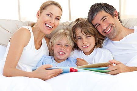 家人在床上看书时微笑图片